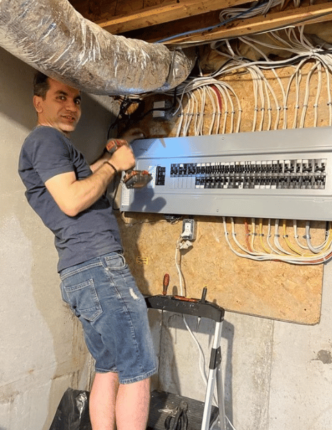 Electrician Farzad Nejatpour at work with circuit breaker panel